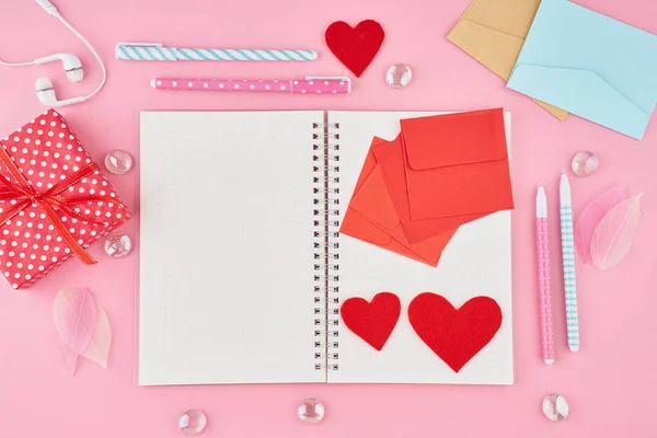 BlanThe concept of writing note, letters for Valentine\'s Day. Notepad page in bullet journal on bright pink office desktop. Top view of modern table with notebook. Mock up, copy space