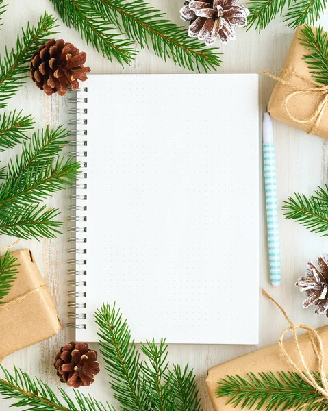 White open notepad, bullet journal for wish list and Christmas decoration on white wooden background, flat lay, copy space. Hand crafted, plastic free, zero waste concept. Mock up
