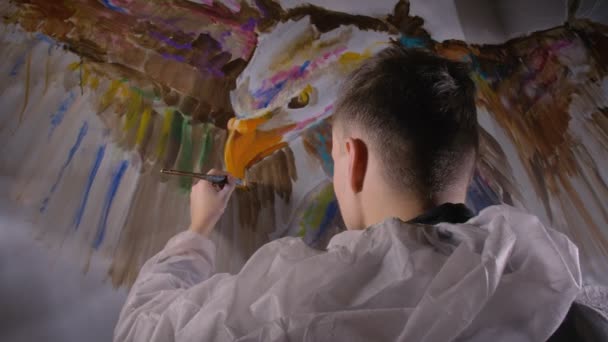 Künstler-Designer zeichnet einen Adler an die Wand. Handwerker Dekorateur malt ein Bild mit Acryl-Ölfarbe. Maler Maler im Anstrich.