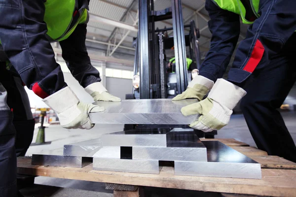 Werknemers nemen van aluminium billet Stockfoto