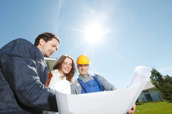 Arbeiter zeigt Hauspläne — Stockfoto