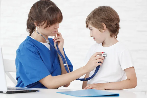 Doutor ouvindo batimento cardíaco de um menino — Fotografia de Stock