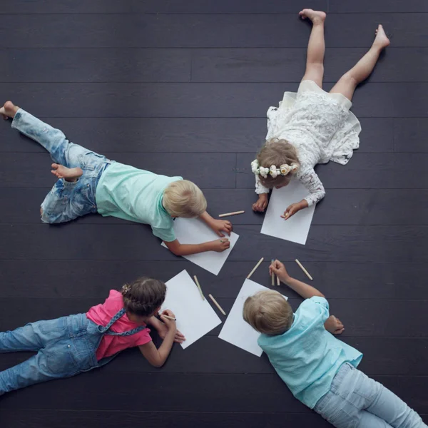 Groupe d'enfants mignons dessinant avec des crayons colorés sur le sol — Photo