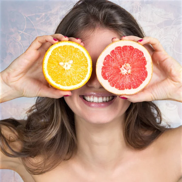 Leende kvinna som håller citrus skivor — Stockfoto