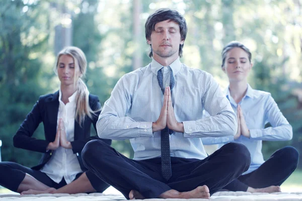 Business people practicing yoga — Stock Photo, Image