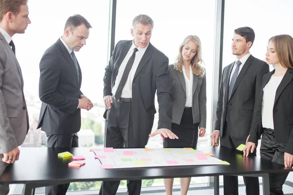 Gente de negocios desarrollando plan en escritorio de oficina — Foto de Stock