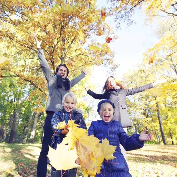 Szczęśliwa rodzina bawiąca się jesienią — Zdjęcie stockowe