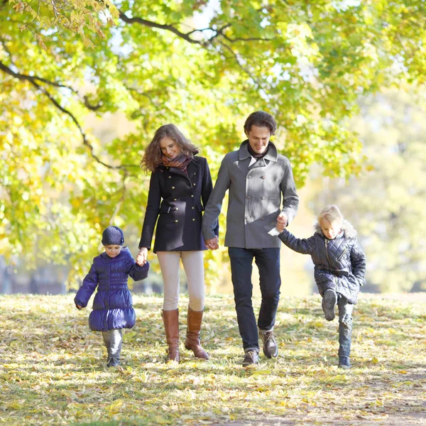 Семья с детьми, гуляющими в осеннем парке — стоковое фото