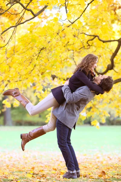 Pareja sonriente abrazándose en el parque de otoño — Foto de Stock