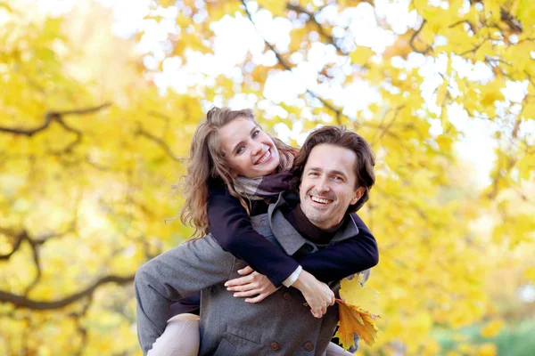 秋の公園で楽しみを持っているカップル — ストック写真