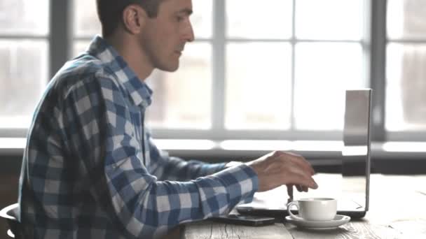 Чоловік працює на ноутбуці — стокове відео