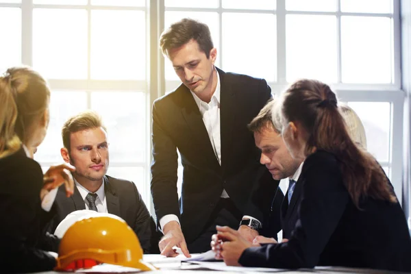 Business people with construction blueprint — Stock Photo, Image