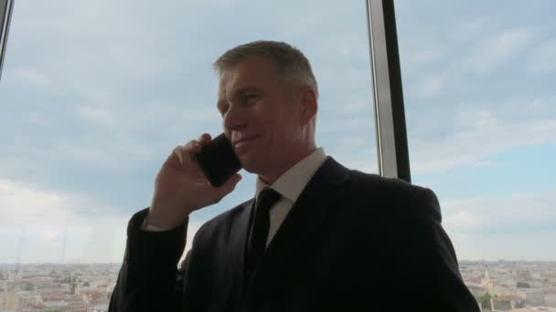 Зрілий бізнесмен розмовляє по телефону — стокове відео