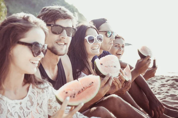 Friends eating watermelon on beach — Stock Photo, Image