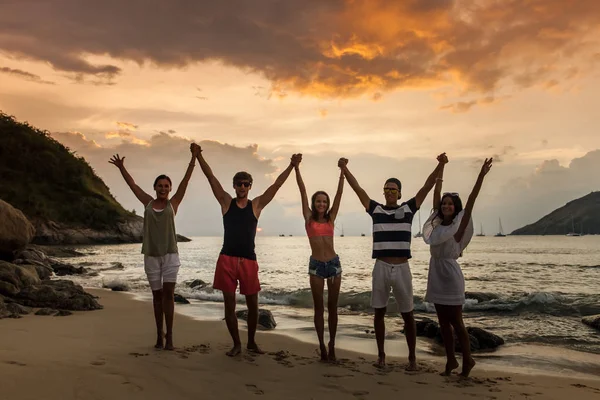 Friends on beach at sunset — Stock Photo, Image