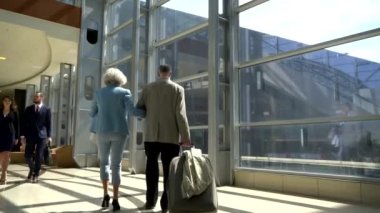 İki yaşlılar bavulla yürüyüş