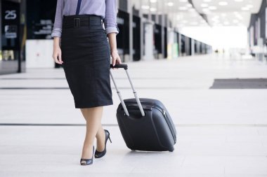 İş kadını ile tekerlekli çanta yürüyüş