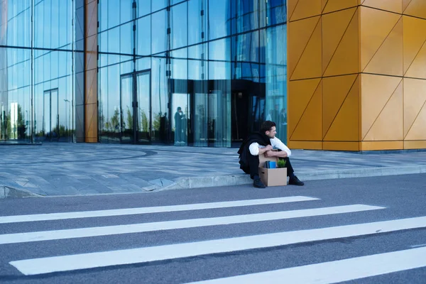 Homme d'affaires viré assis dans la rue — Photo