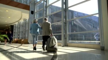 İki yaşlılar bavulla yürüyüş