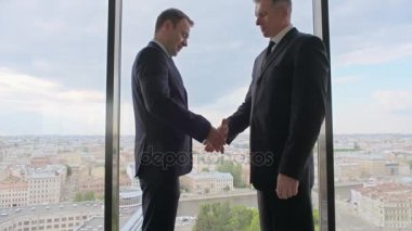 el sıkışan iki gülümseyen iş adamları