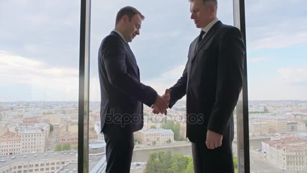 Dois empresários sorridentes apertando as mãos — Vídeo de Stock
