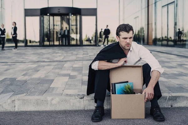 Homme d'affaires viré assis dans la rue — Photo