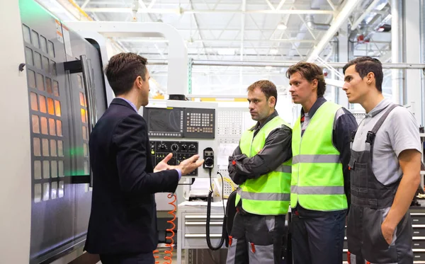 Gerente y trabajadores cerca de máquinas CNC — Foto de Stock