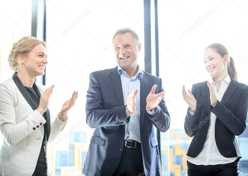 Business group clapping and smiling