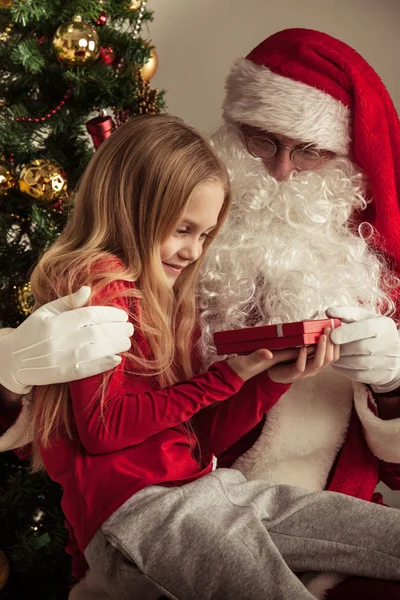 Girl on santa claus knees Stock Photo