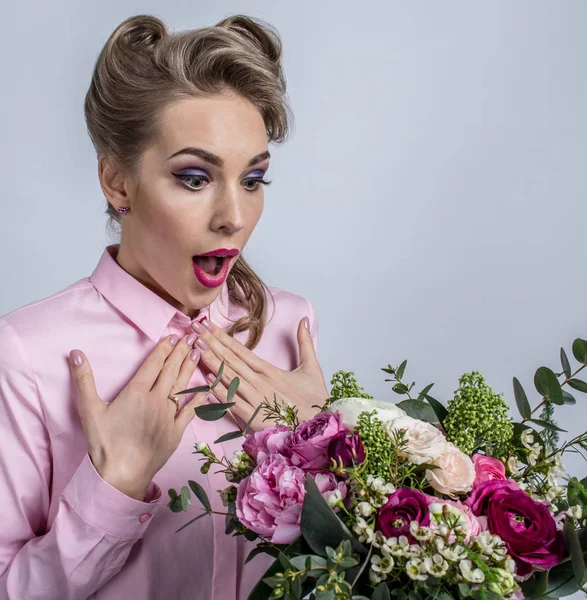 Mulher surpreendida com um monte de flores — Fotografia de Stock