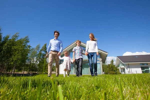 Family walking on lawn near house — Stock Photo, Image