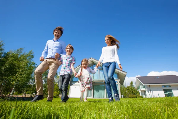 Familie draait op gazon in de buurt van huis — Stockfoto