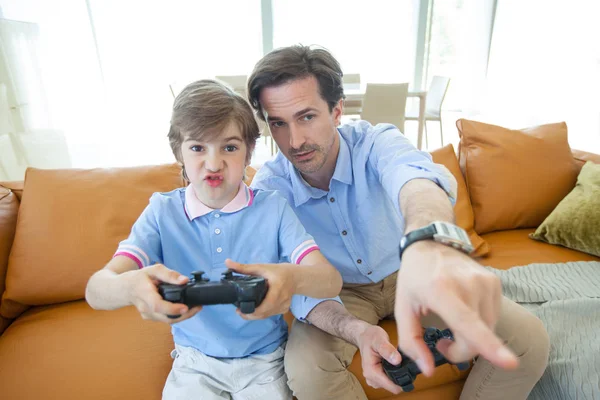 Pai e filho jogando videogame em casa — Fotografia de Stock