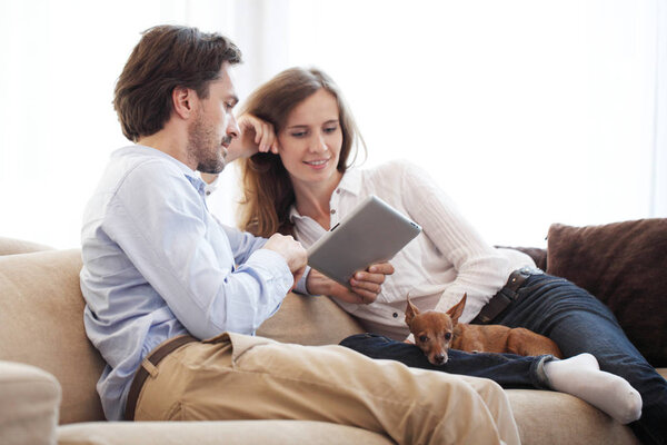 Cheerful couple using tablet 