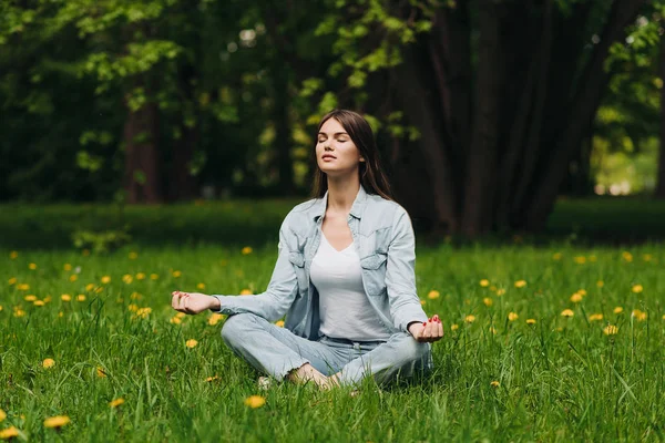 Jong meisje mediteren in park — Stockfoto