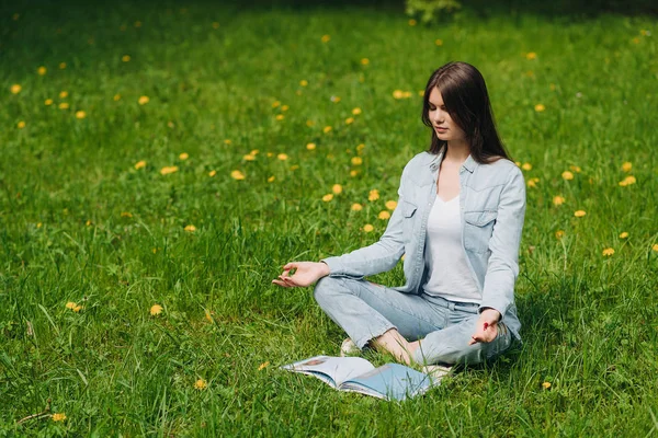 Jong meisje mediteren in park — Stockfoto