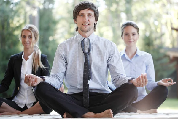 Business people practicing yoga — Stock Photo, Image