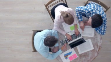 İş ekibi toplantısı, günlük kıyafet giyen insanlar ofis masasında mali istatistiklerle çalışıyorlar.