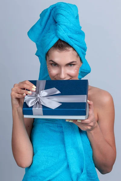 Kvinna med handduk på huvudet öppna presentförpackning — Stockfoto