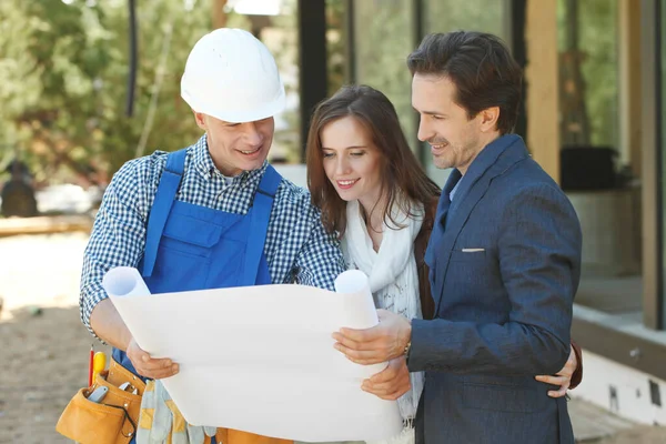 Foreman muestra planos de diseño de la casa — Foto de Stock