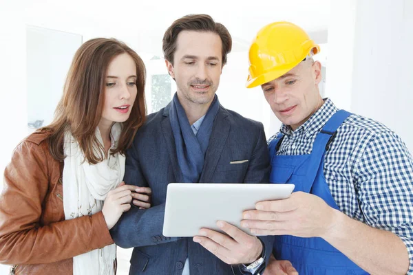 Worker and couple look at tablet — Stock Photo, Image