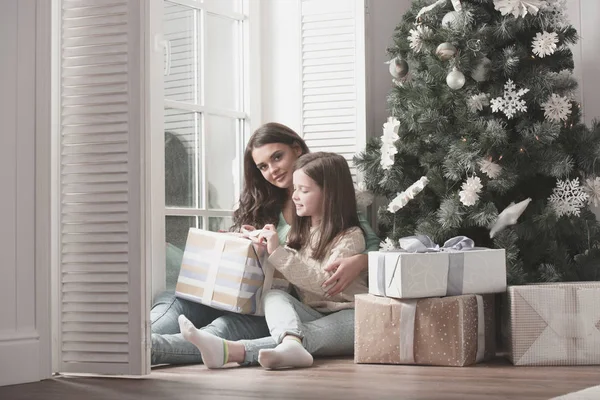 Madre e hija desempaquetan regalo de Navidad — Foto de Stock