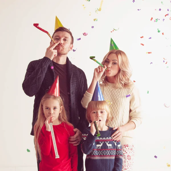 Família soprando trompetes de festa com confete — Fotografia de Stock