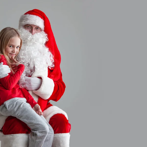 Girl on santa claus knees Stock Picture