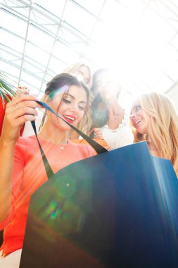 Kadınlar alışveriş çantasının içine bakar.