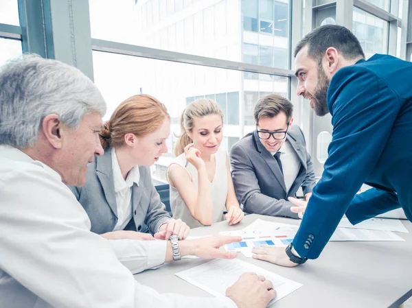 Business people discussing diagrams — Stock Photo, Image