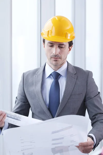 Arquitecto en hardhat con plano — Foto de Stock