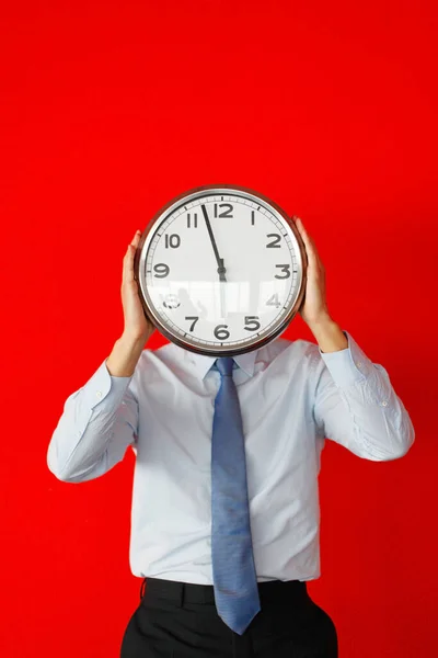 Empresario Cubriendo Cara Con Reloj Pared Sobre Fondo Rojo — Foto de Stock