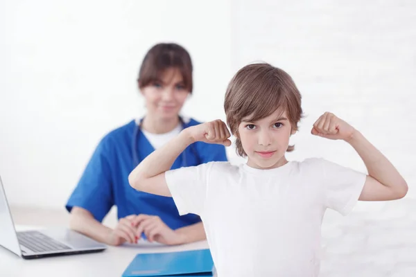 Criança Saudável Mostrando Músculos Consultório Pediatra Médico Feminino Segundo Plano — Fotografia de Stock