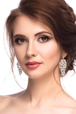 Güzellik Portresi. Düğün makyaj ve saç modeli beyaz arka plan üzerinde izole poz güzel genç kadın. Glamour kristal küpe ile bak. Sağlıklı parlak deri 